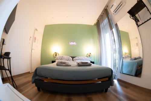 a bed in a room with a green wall at Altopiano Rooms Suite in Foggia