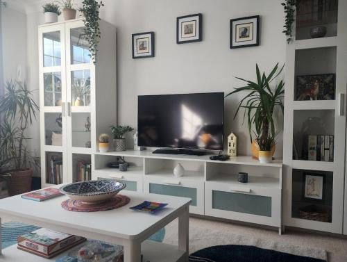 a living room with a tv and a white entertainment center at The Peak Retreat in Longdendale