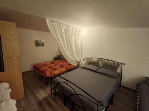 a bedroom with two beds and a curtain at Presolana House in Castione della Presolana