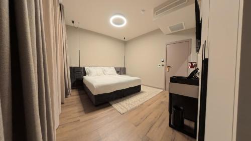 a bedroom with a white bed and wooden floors at Hotel Aquarius Dubrovnik in Dubrovnik