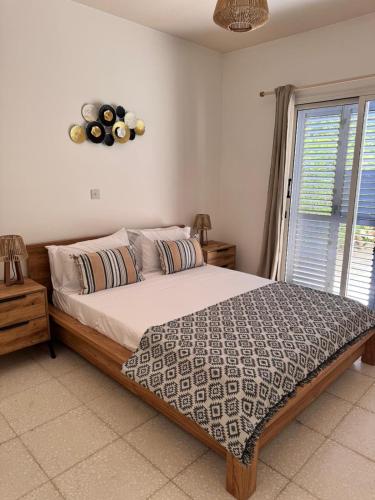 a bedroom with a large bed and a window at Paphos - Paradise Gdns 1BR with Pool, Terrace, Parking in Paphos City