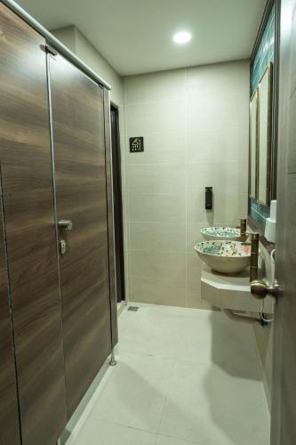 a bathroom with two sinks and a glass shower stall at Soultel โซลเทล in Khlong San