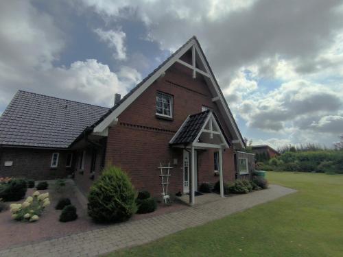 a red brick church with a cross in front of it at FeWo Südertoft - gemütliche Unterkunft für bis zu 3 Personen in Wallsbüll
