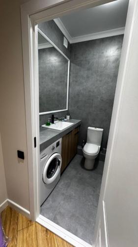 a bathroom with a toilet and a sink and a mirror at 2 room apartment, ЖК Кристалл in Almaty