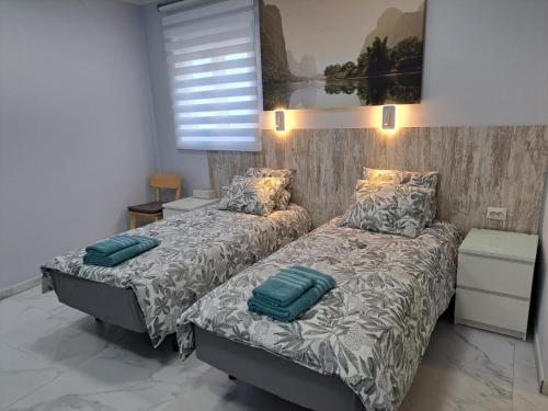 a bedroom with two beds and a window at Casa Tartago in Triana