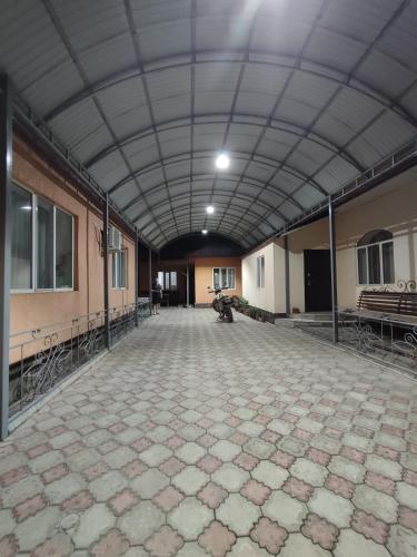 a large room with a stone floor and a ceiling at Oskar in Toktogul