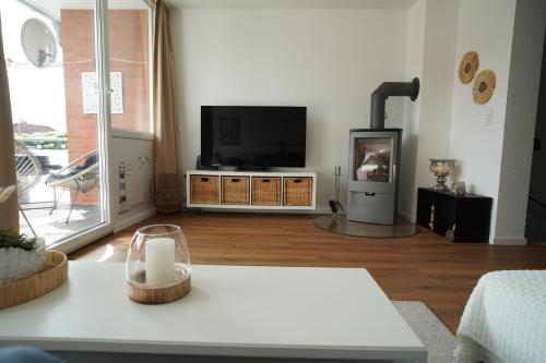 a living room with a flat screen tv on a table at Ferienhaus Meerzeit-Hooksiel in Hooksiel