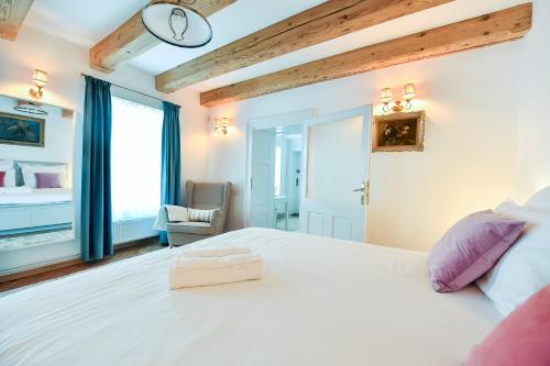 ブラショヴにあるCasa Baritiu Roomsのベッドルーム(紫色の枕が付いた大きな白いベッド付)