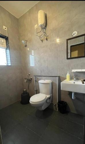 a bathroom with a toilet and a sink at ECR Happy Nest villa in Mahabalipuram