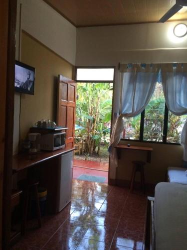 a room with a kitchen with a desk and a window at Aloha Surf Nosara - Kahala Hui Cabins #3 in Nosara