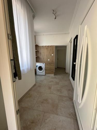 a hallway of a kitchen with a washing machine at Noémi Apartman Újfehértó in Újfehértó