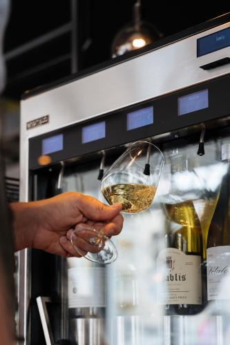 a person is holding a glass of wine at Cosmopolite Hotel Nieuwpoort-Bad in Nieuwpoort