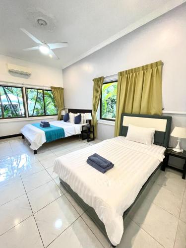 two beds in a large room with windows at Birdcage Boutique in Phnom Penh