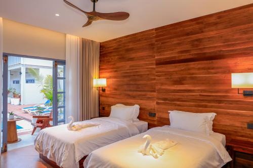 two beds in a hotel room with swans on them at Viriya Hotel in Luang Prabang