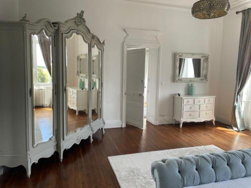 a living room with a large mirror and a dresser at Chateau de Minargent in Aulnay
