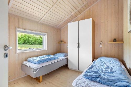 a bedroom with two beds and a window at 6840-Allinge-Gjedelokken-23 in Allinge