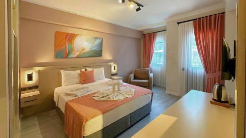 a hotel room with a bed and a chair at Casa De Levıssı Ölüdeniz in Oludeniz