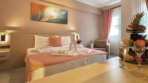 a hotel room with a bed and a table with wine glasses at Casa De Levıssı Ölüdeniz in Oludeniz