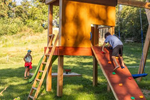 a man is playing on a play structure at Le Galussel Gite d'étape et de séjour in Saint-Sébastien