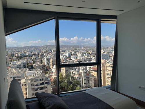 a bedroom with a view of a city at Oceanfront 3BR in The One Tower, Limassol in Limassol