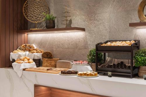 a bakery with bread and pastries on a counter at voco Stockholm - Kista by IHG in Stockholm