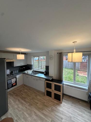 a large kitchen with white cabinets and a large window at Tartan Nest- Entire house- Sleeps 8 guests in Mansewood