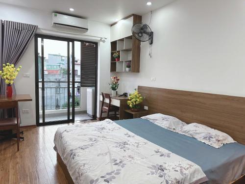 a bedroom with a bed and a desk and a window at Sông Tranh 402MD in Hanoi