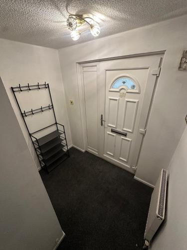 a hallway with a white door and a stair case at Tartan Nest- Entire house- Sleeps 8 guests in Mansewood