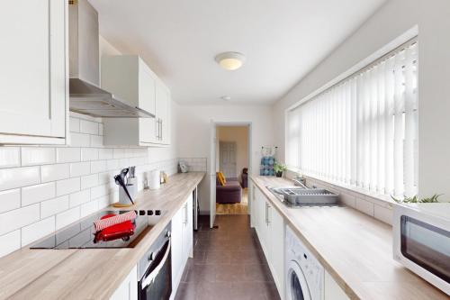 a kitchen with white counters and white appliances at Sunderland Cosy Cottage in Sunderland