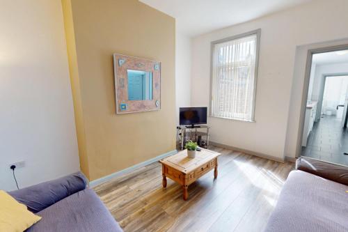 a living room with a couch and a table at Sunderland Cosy Cottage in Sunderland