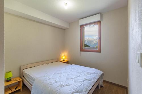 a bedroom with a white bed and a window at Le Balcon de Barèges - Vue Montagne in Barèges