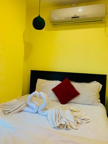 a bed with a pile of towels on it at Hotel Relax Inn Sylhet in Sylhet