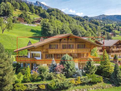 a large wooden house in the middle of a mountain at Orion - Luxuriöse Duplex Wohnung in Grindelwald in Grindelwald