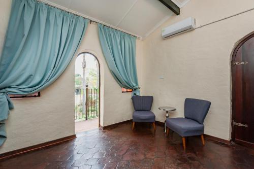 two chairs and a table in a room with a window at Airport Tower Lodge in Kempton Park