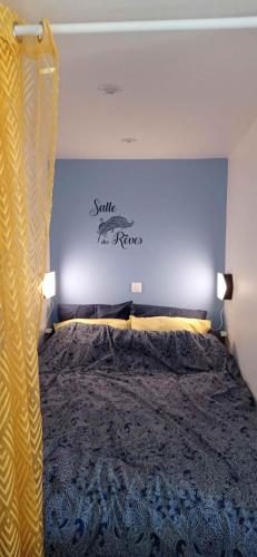 a bedroom with a bed with a sign on the wall at Bleu - 3 star small gite with hot tub and heated pool in Mantilly