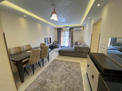 una sala de estar con una mesa y un sofá en Alrehab Cheapest and awesome, en Burg el-Ḥudûd