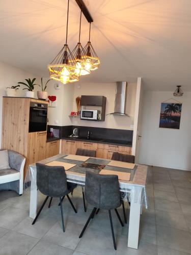 Una cocina con mesa de comedor y sillas. en Trébeurden appartement T 3 vue mer 3 ***, en Trébeurden