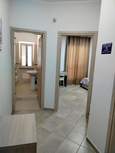 a room with two doors and a bathroom with a sink at Stanza vacanza lo stadio in Sibari