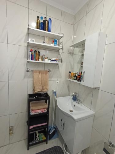 a white bathroom with a sink and a toilet at side side in Side