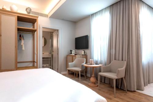 a hotel room with a bed and a table and chairs at ICON Malabar in Málaga