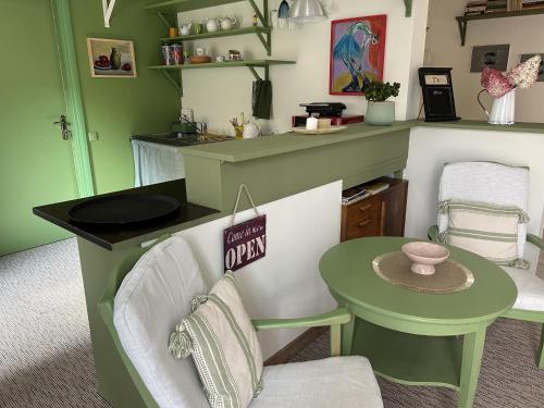 a kitchen with a green and white counter and a table at Saga studio in the center of Pasvalys in Pasvalys