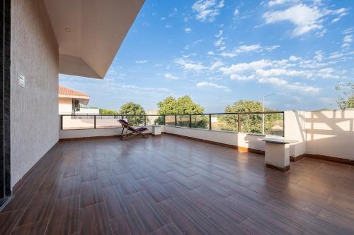 a large room with a balcony with a wooden floor at Urban Hideout - a mini farmhouse in Jaipur