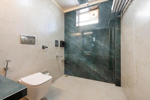 a bathroom with a shower and a toilet at Urban Hideout - a mini farmhouse in Jaipur