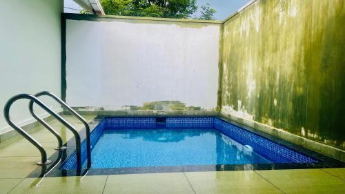 a swimming pool in the side of a building at The village vista in Batheri