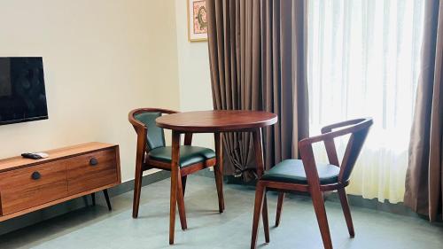 a room with a table and two chairs and a dresser at The village vista in Batheri
