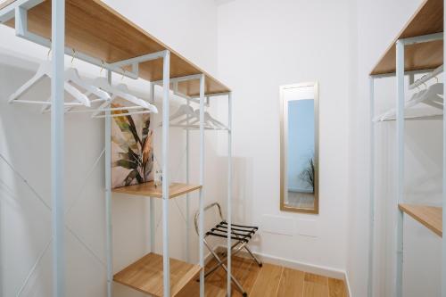 a room with glass shelves and a chair at Rena Bianca Apartments in Porto Torres
