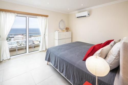 a bedroom with a bed and a view of the ocean at Casa Carvoeiro Bay J in Carvoeiro