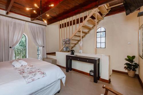 a bedroom with a white bed and a staircase at Airport Tower Lodge in Kempton Park