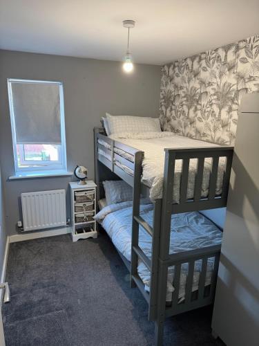 a small bedroom with a bunk bed and a window at 14 Lumb close in Swindon