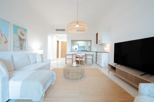 a living room with a couch and a flat screen tv at 2 bedroom Tranquil Retreat in Ansam in Abu Dhabi